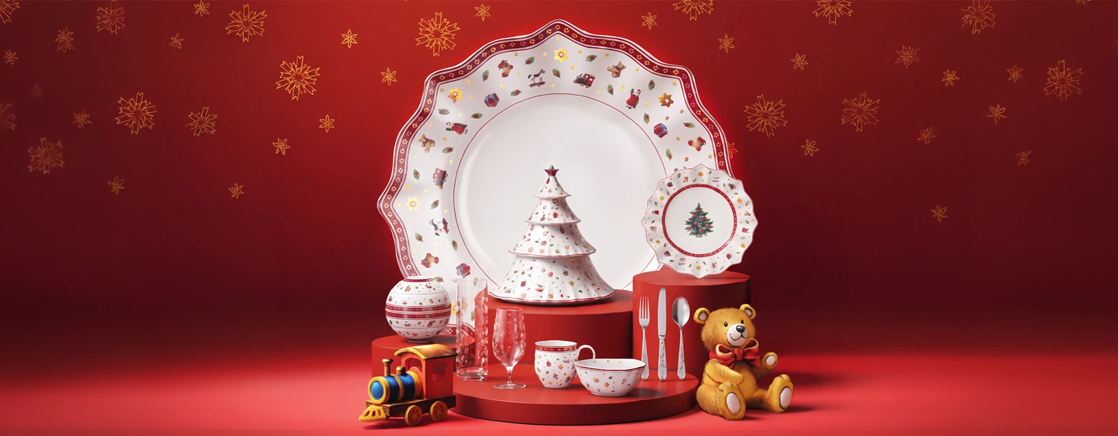 Новогодняя композиция Toy’s Delight на красном фоне: фарфор, ёлочка, игрушечный поезд и медвежонок